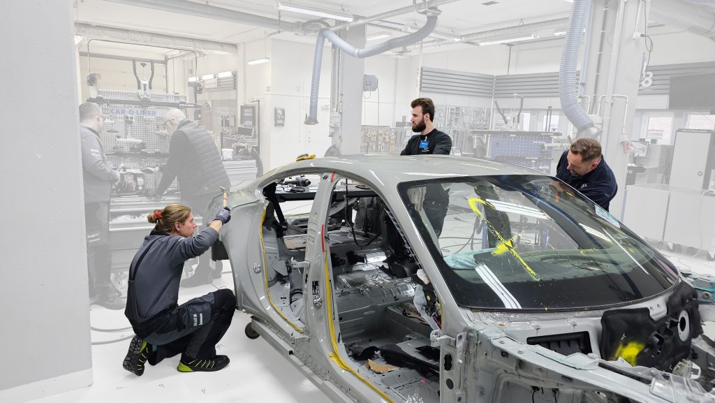 Technicians working on automotive frame