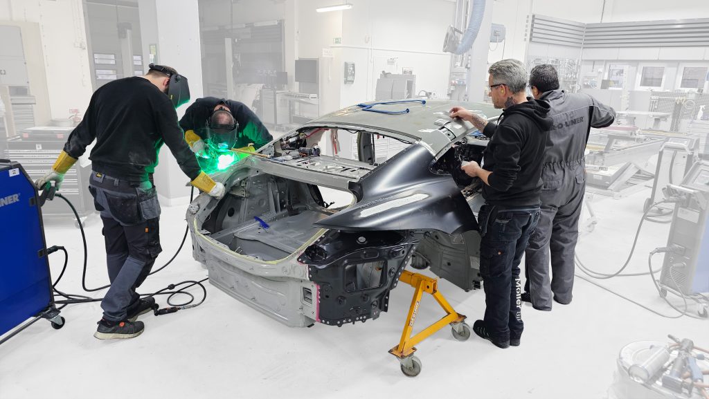 Technicians performing a weld on a damaged frame